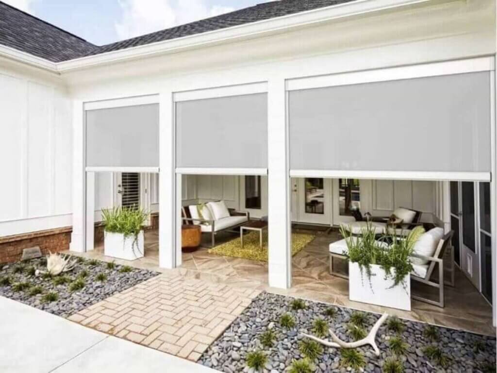 outdoor roller shades installed on a contemporary home, shielding against harsh sunlight